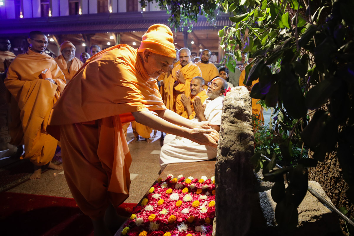 Swamishri reverentially touches a stone sanctified by Aksharbrahman Gunatitanand Swami