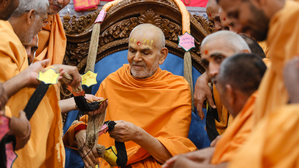 Swamishri sanctifies a garland