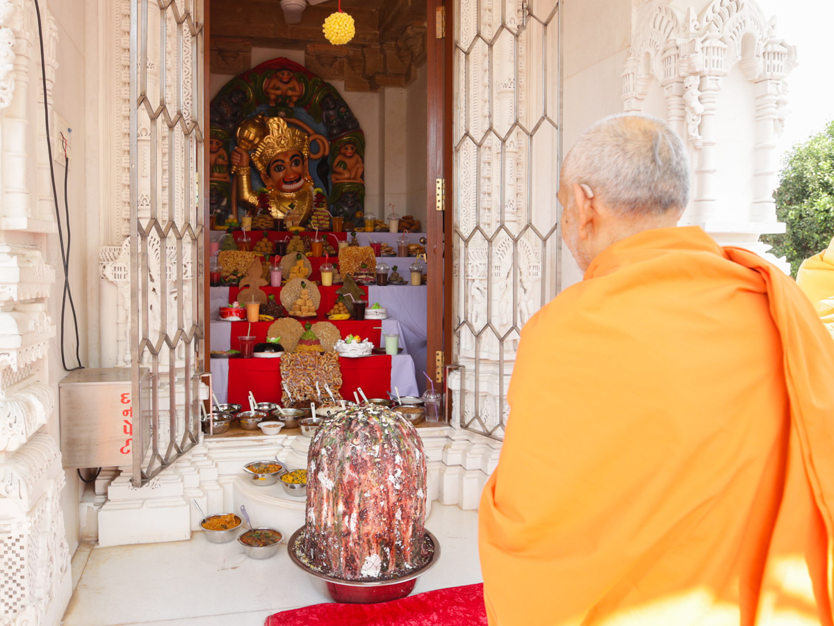 Swamishri doing darshan of annakut offered to Shri Hanumanji