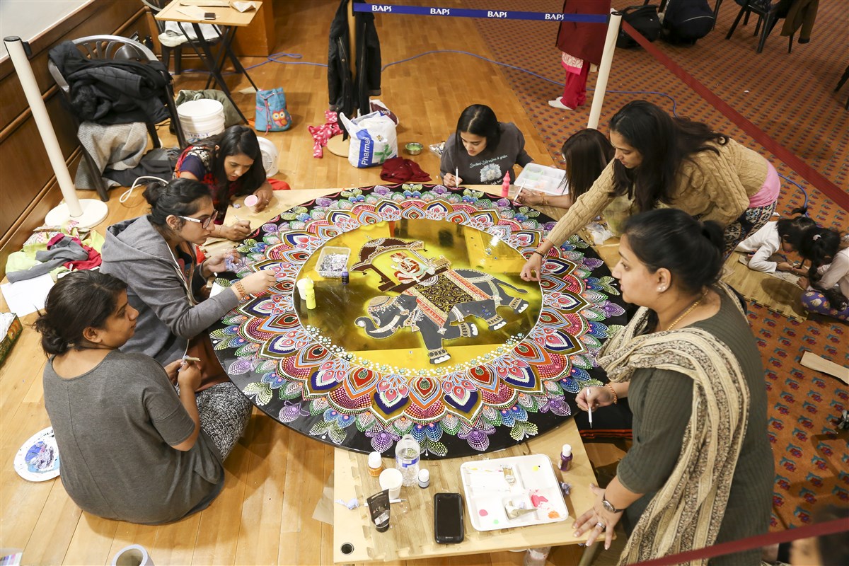 Volunteers prepare a hall rangoli