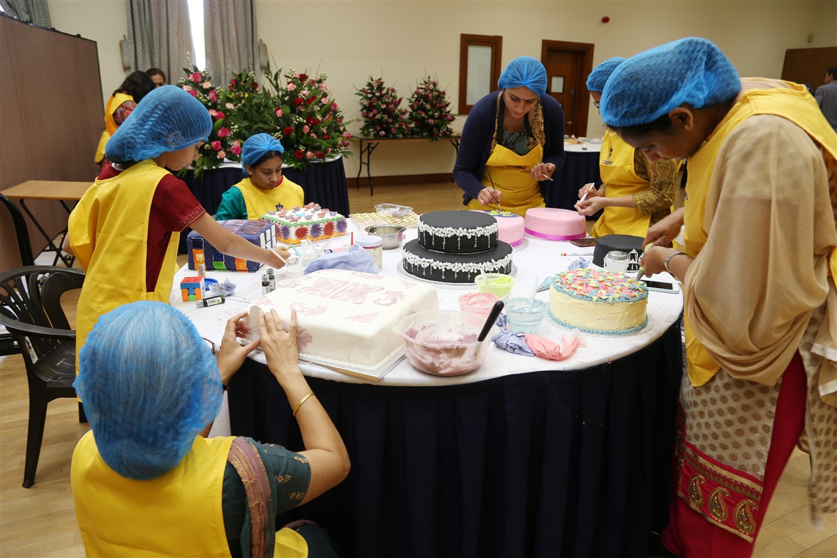 Volunteers prepare decorative cakes
