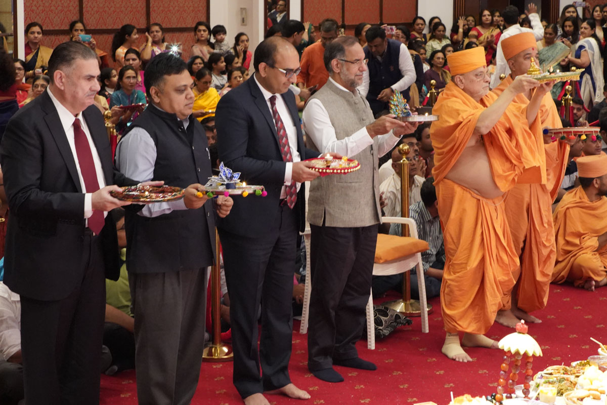 Pujya Ishwarcharan Swami, Brahmavihari Swami, Ambassador of India, Consul General of India and guests perform the main annakut arti