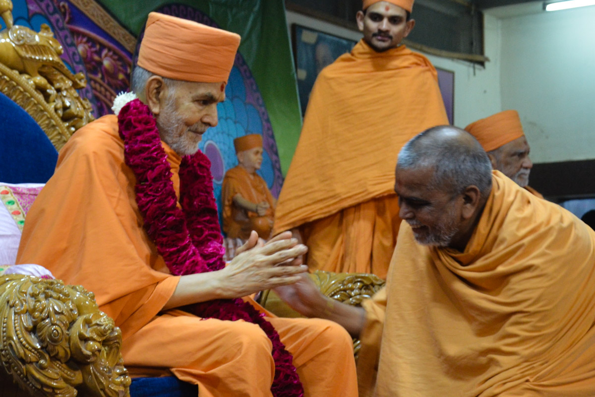 Vedagna Swami welcomes Swamishri with a garland