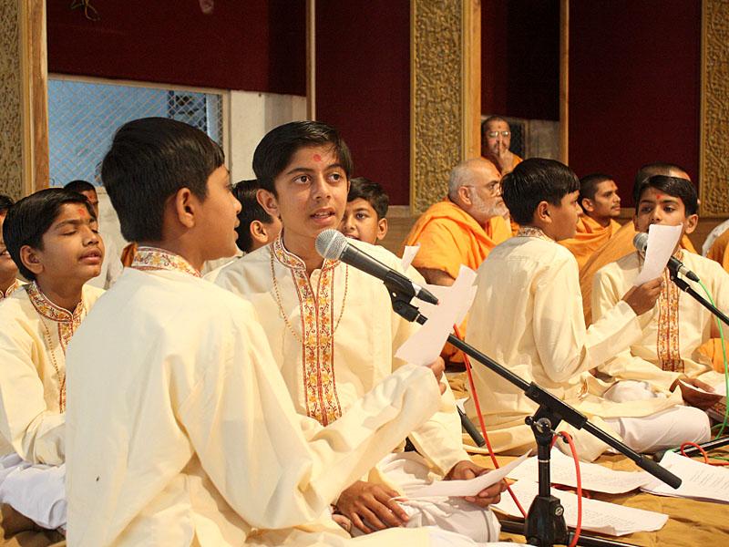 Children sing kirtans in Swamishri's morning puja
