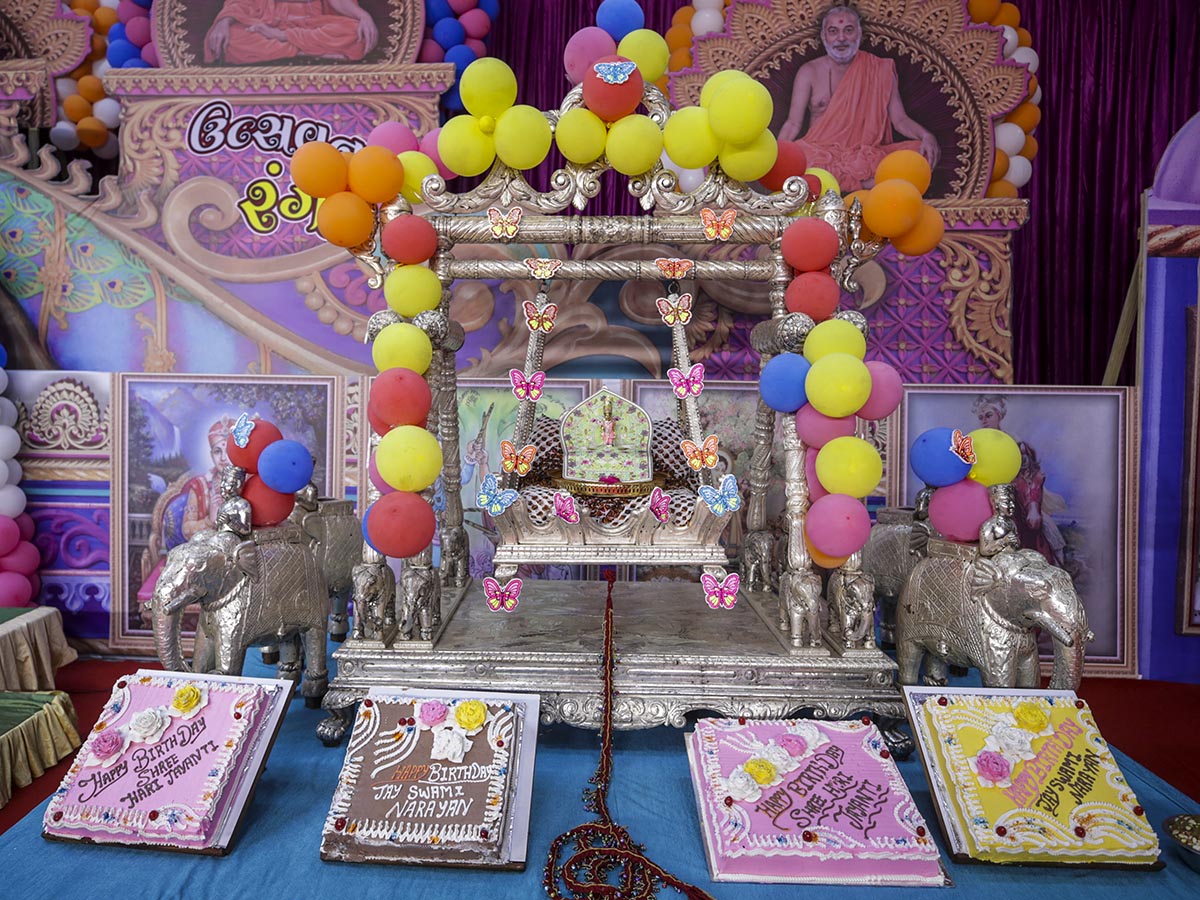 Shri Harikrishna Maharaj in a hindolo adorned for a symbolic Shri Hari Jayanti Celebration