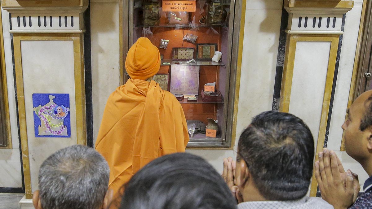 Swamishri engrossed in the darshan of holy relics of Bhagwan Swaminarayan