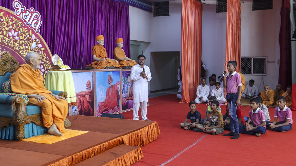 Youths and children interact with Swamishri
