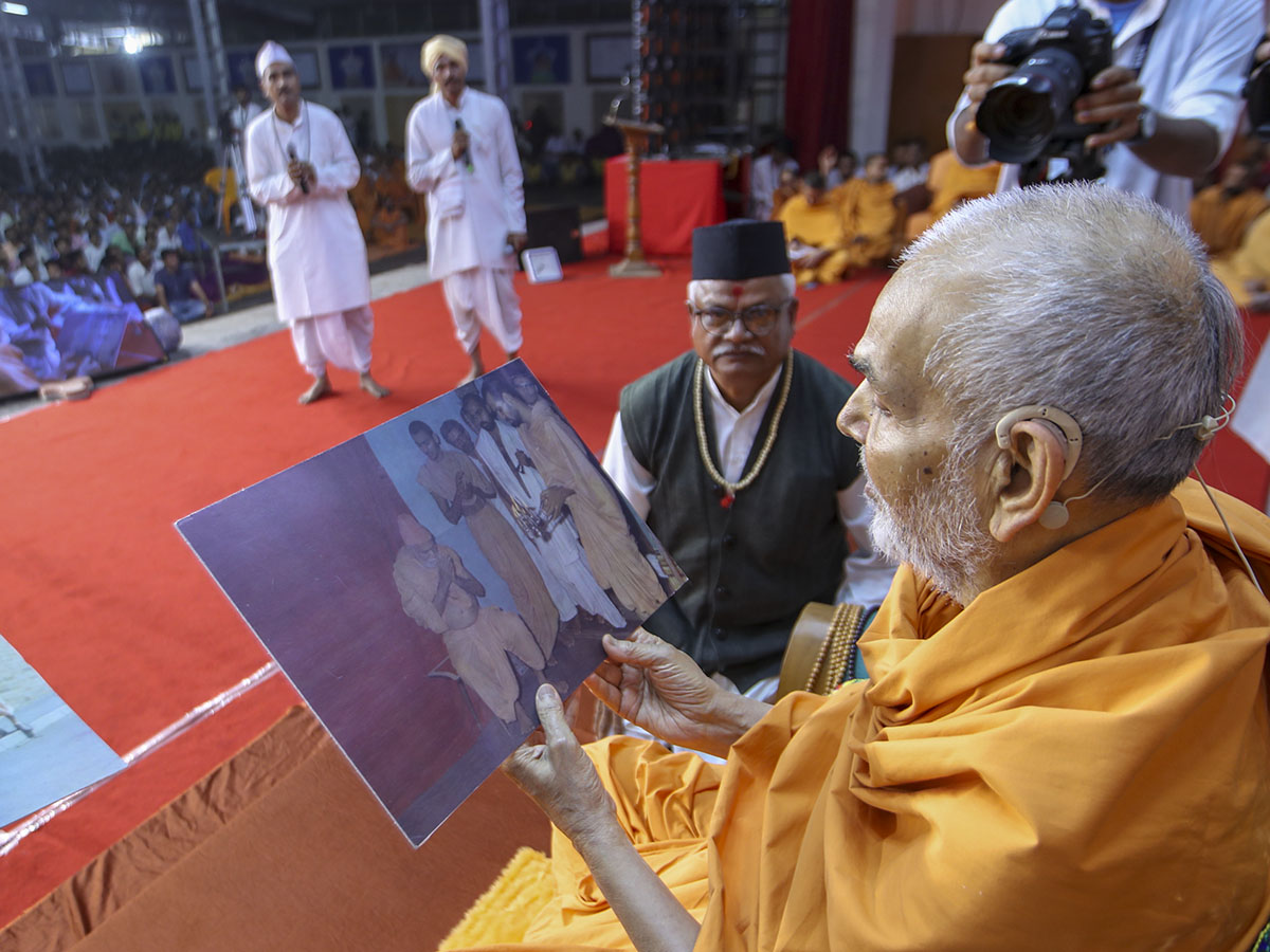 Swamishri observes an old photograph