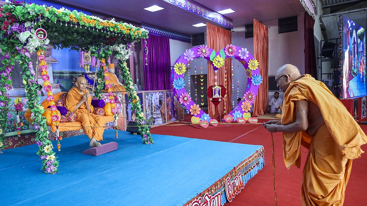Pujya Bhaktipriya Swami (Kothari Swami) swings Swamishri in a hindolo