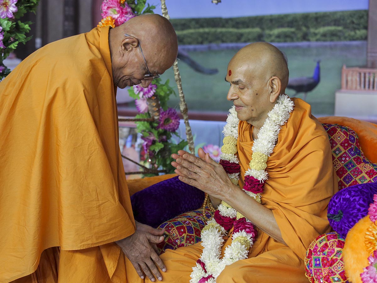 Pujya Swayamprakash Swami (Doctor Swami) honors Swamishri with a garland