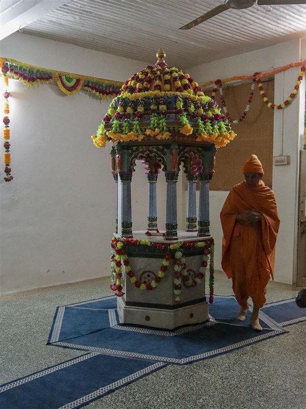 Swamishri performs pradakshina of the shrine of Purushottamdas Swami (Khandeshi)