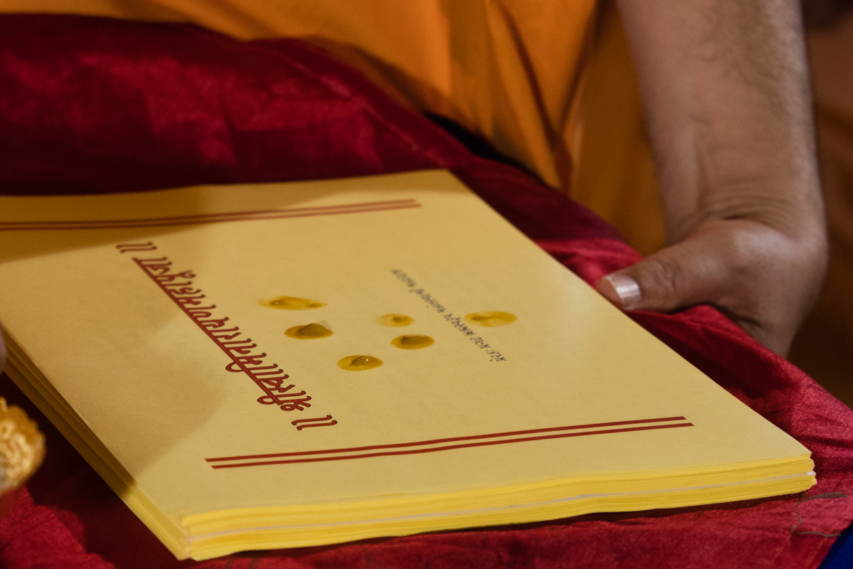 Swamishri sanctifies the 'Swaminarayan Mahapuja' text