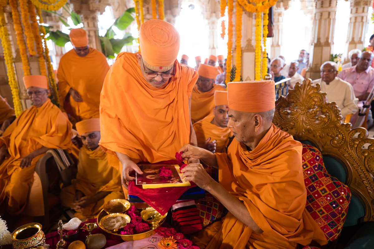 Swamishri sanctifies the 'Swaminarayan Mahapuja' text