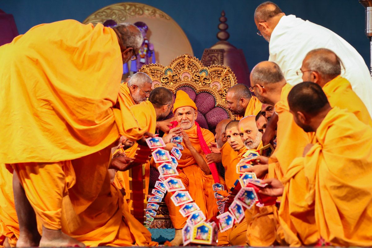 Sadhus honor Swamishri with a garland