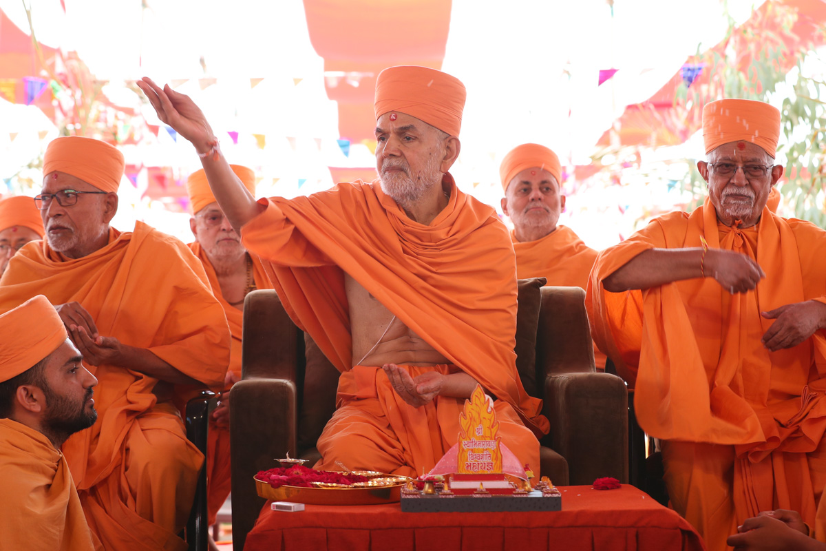 Swamishri blesses the devotees by showering rice grains