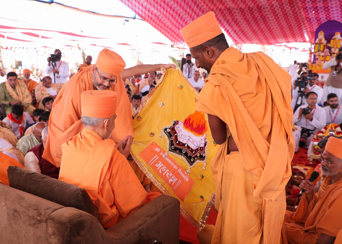 Swamishri observes a shawl
