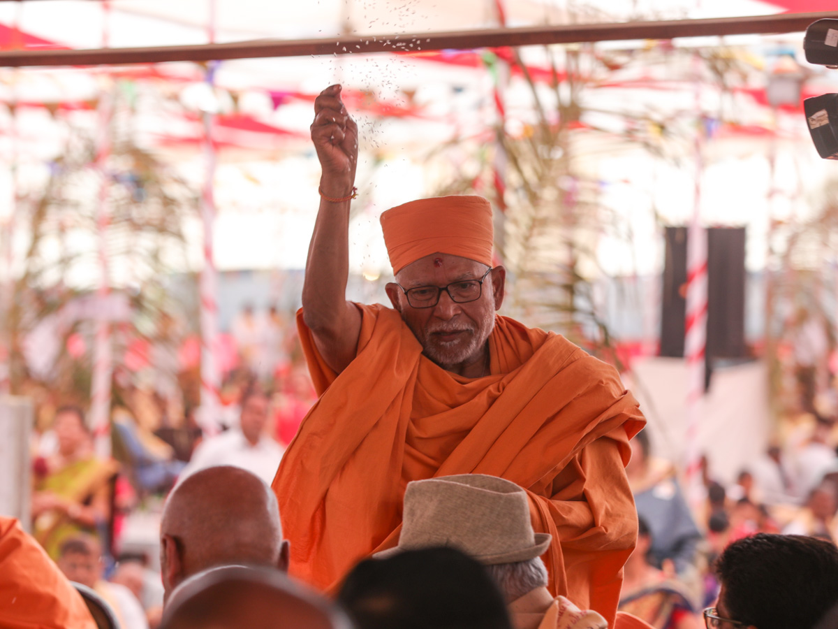 Pujya Bhaktipriya Swami (Kothari Swami) blesses devotees by showering rice grains