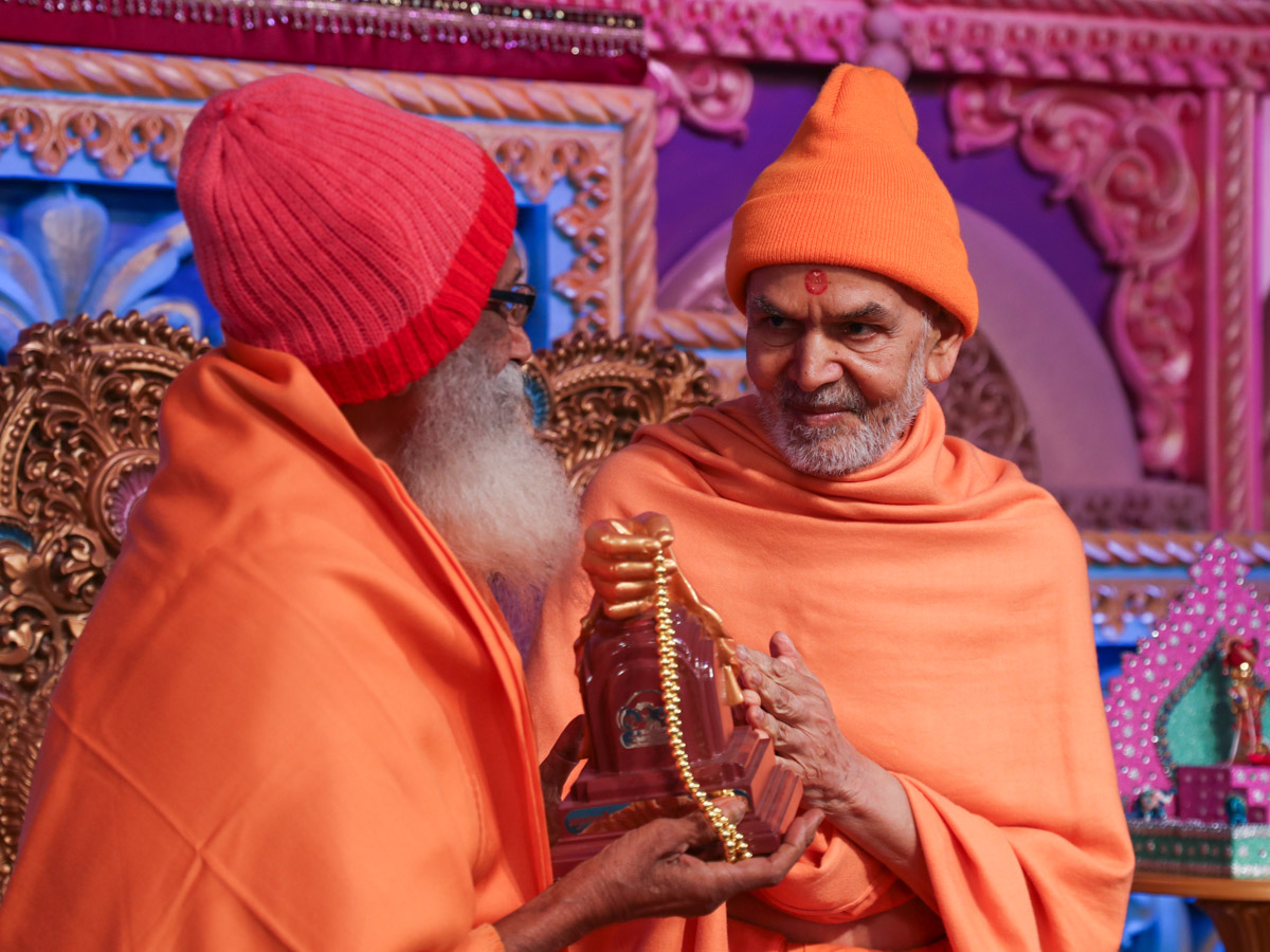 Swamishri presents mementos to invited guests