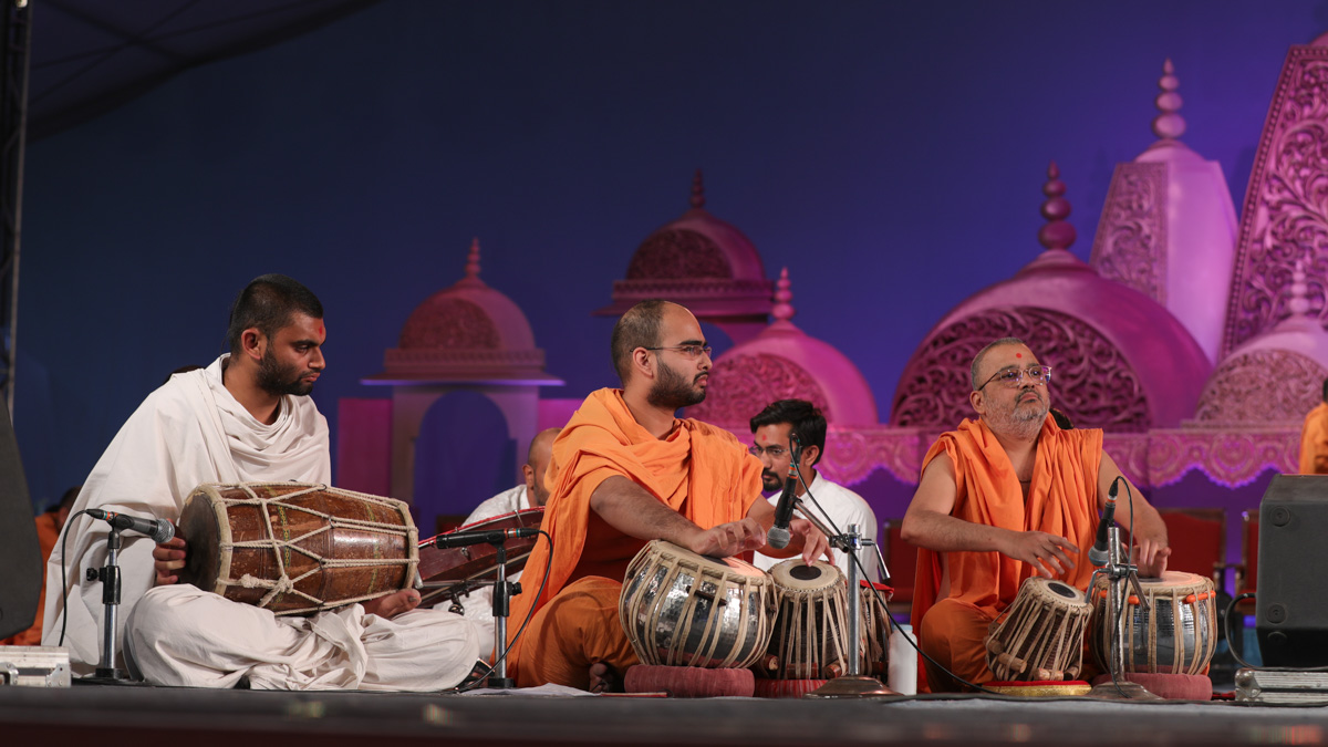 Sadhus and a parshad play musical instruments