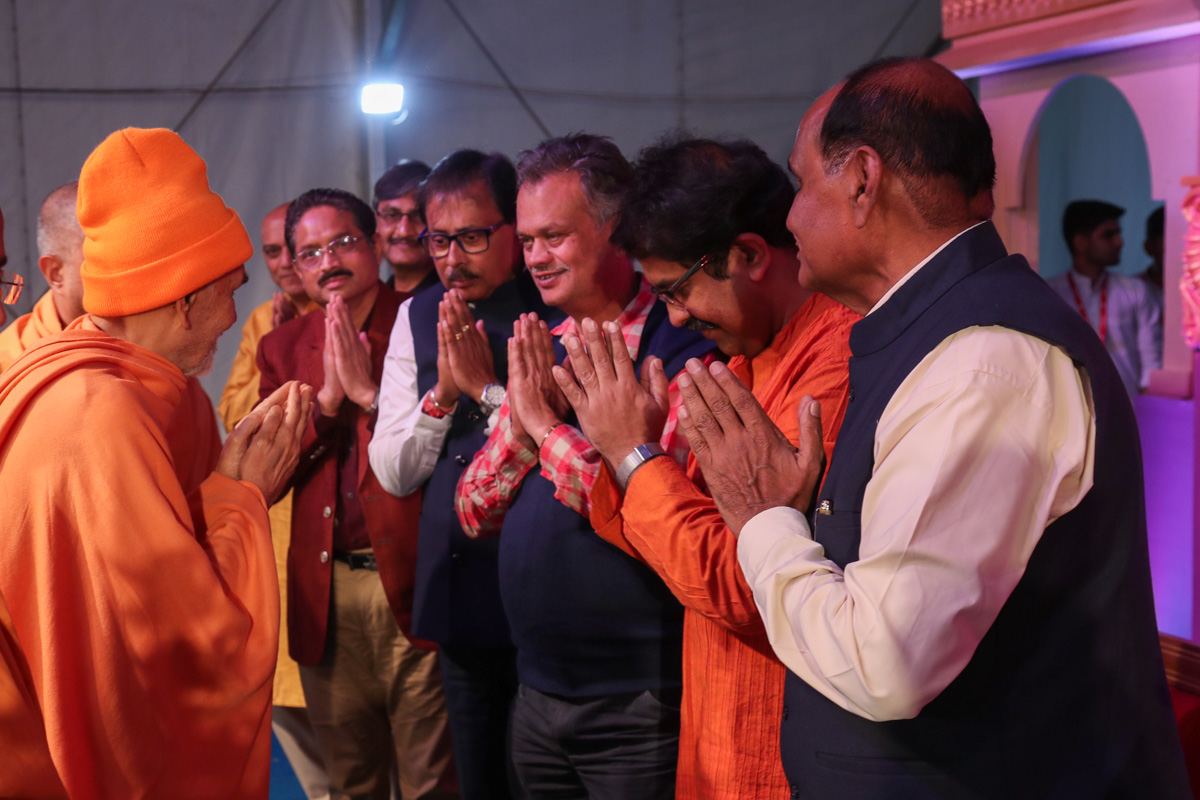 Swamishri greets invited guests in the evening satsang assembly