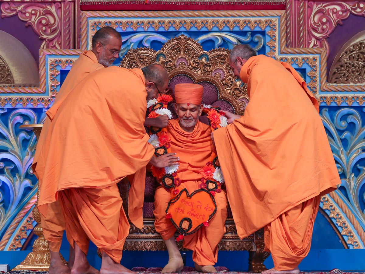 Sadhus honor Swamishri with a garland