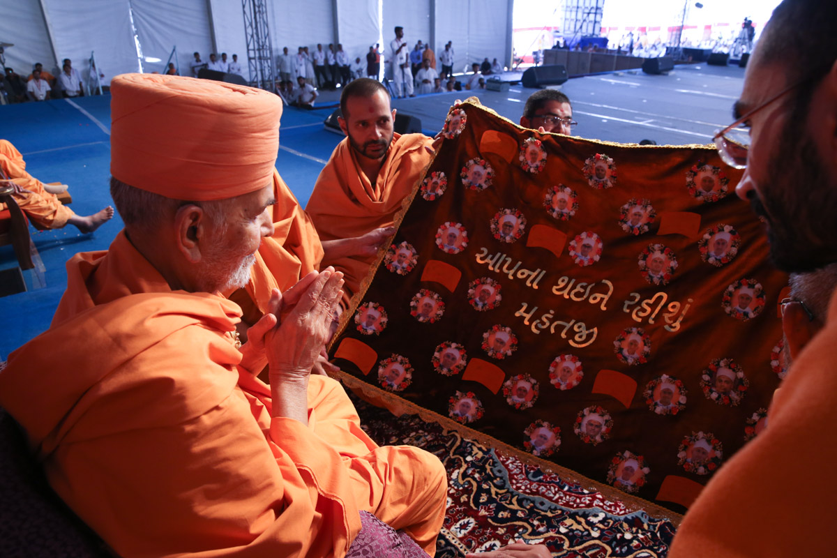 Swamishri observes a shawl