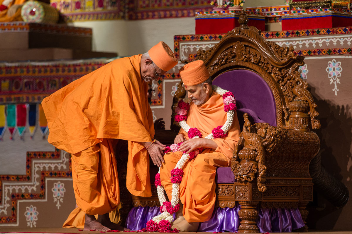Pujya Doctor Swami honors Swamishri with a garland