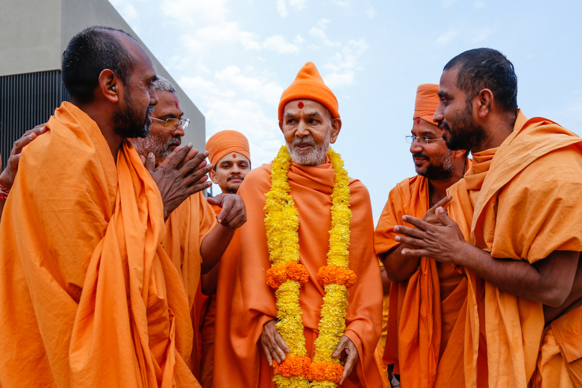 Sadhus honor Swamishri with a garland before he departs from Rajkot