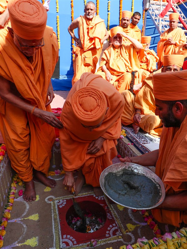 Swamishri pours cement in the pit