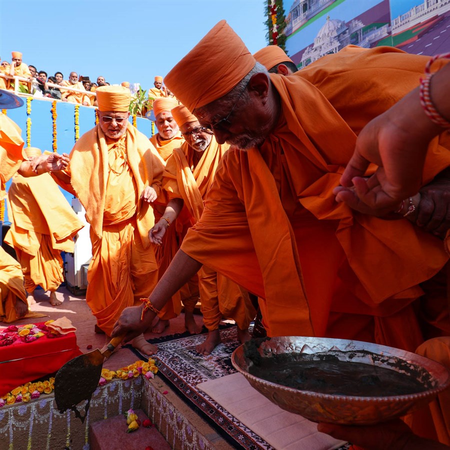 Pujya Swayamprakash Swami (Doctor Swami) pours cement in the foundation pit