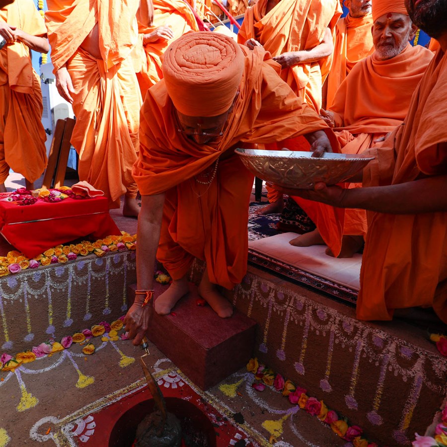 Pujya Tyagvallabh Swami pours cement in the foundation pit
