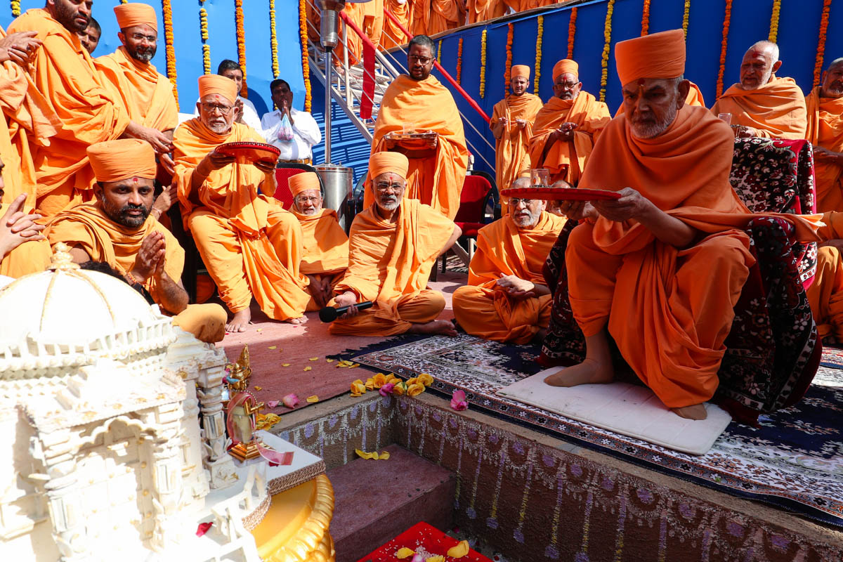Swamishri and senior sadhus perform the arti