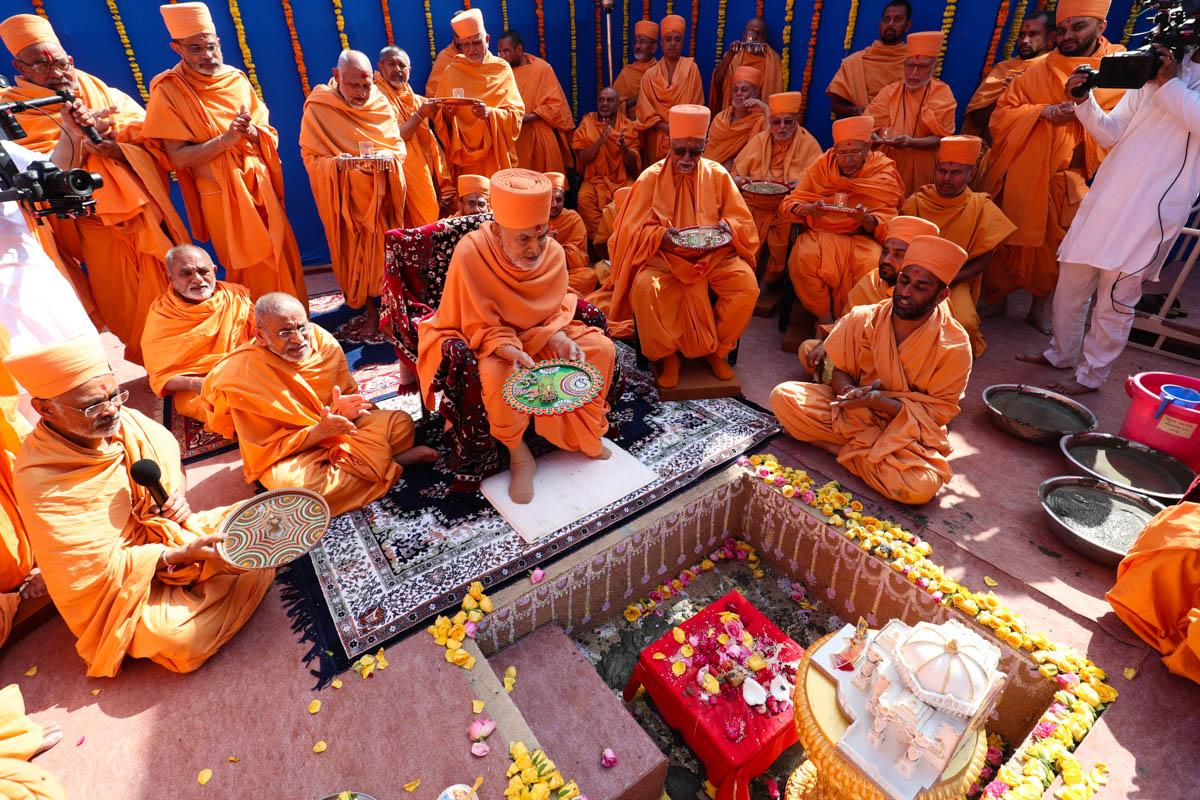 Swamishri and senior sadhus perform the arti