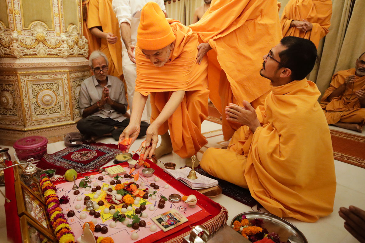 Swamishri offers mantra-pushpanjali during the morning mahapuja