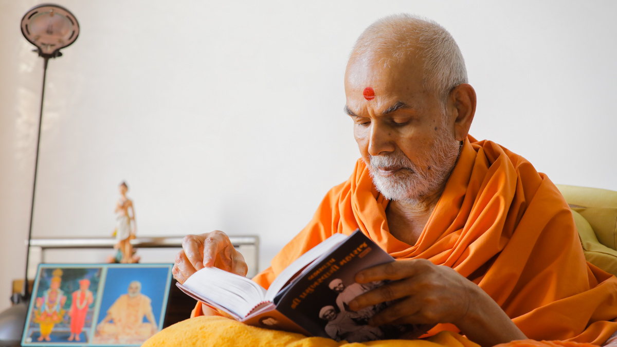 Swamishri reads the newly published jivancharitra of Brahmaswarup Shri Pramukh Swami Maharaj, Part 1