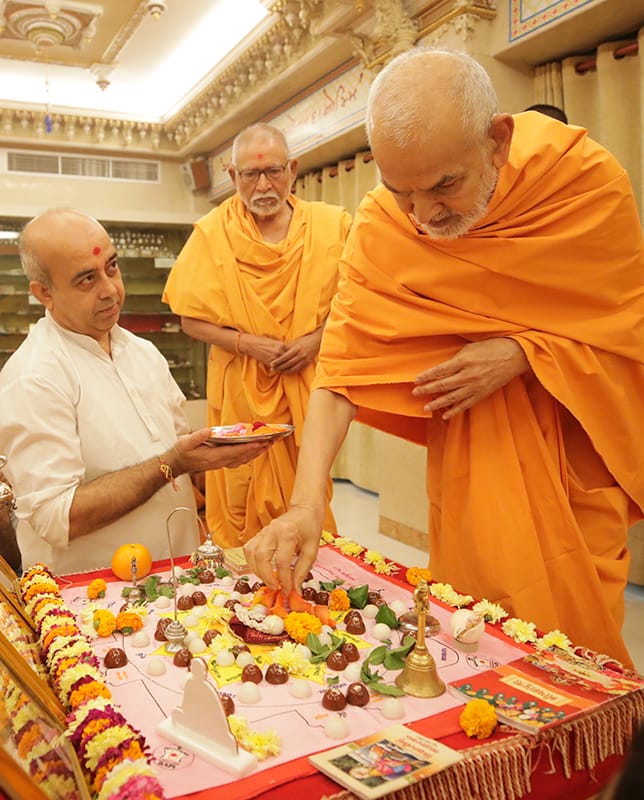 Swamishri offers mantra-pushpanjali during the morning mahapuja