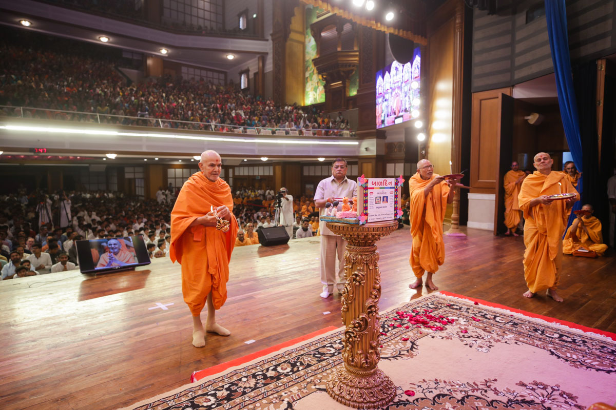 Swamishri, Pujya Bhaktipriya Swami (Kothari Swami), Pujya Viveksagar Swami and an invited guest perform the evening arti