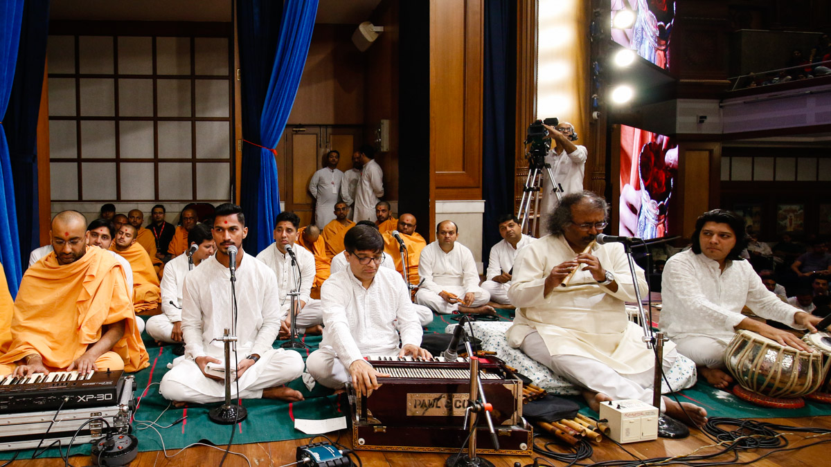 Shri Sandip Kulkarni plays the flute in Swamishri's morning puja