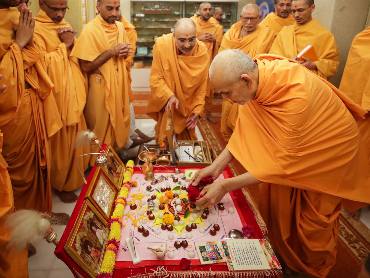 Swamishri offers mantra-pushpanjali in the morning mahapuja