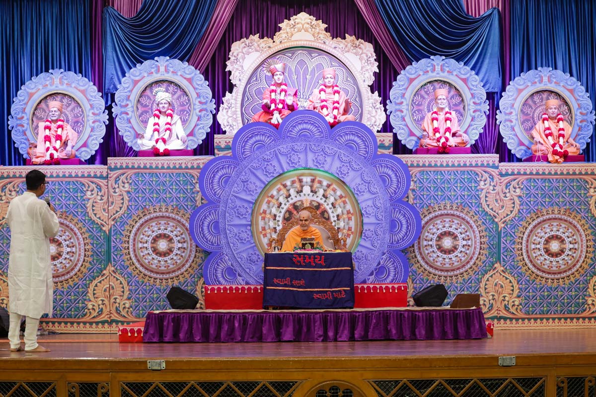 A devotee presents mukhpath before Swamishri