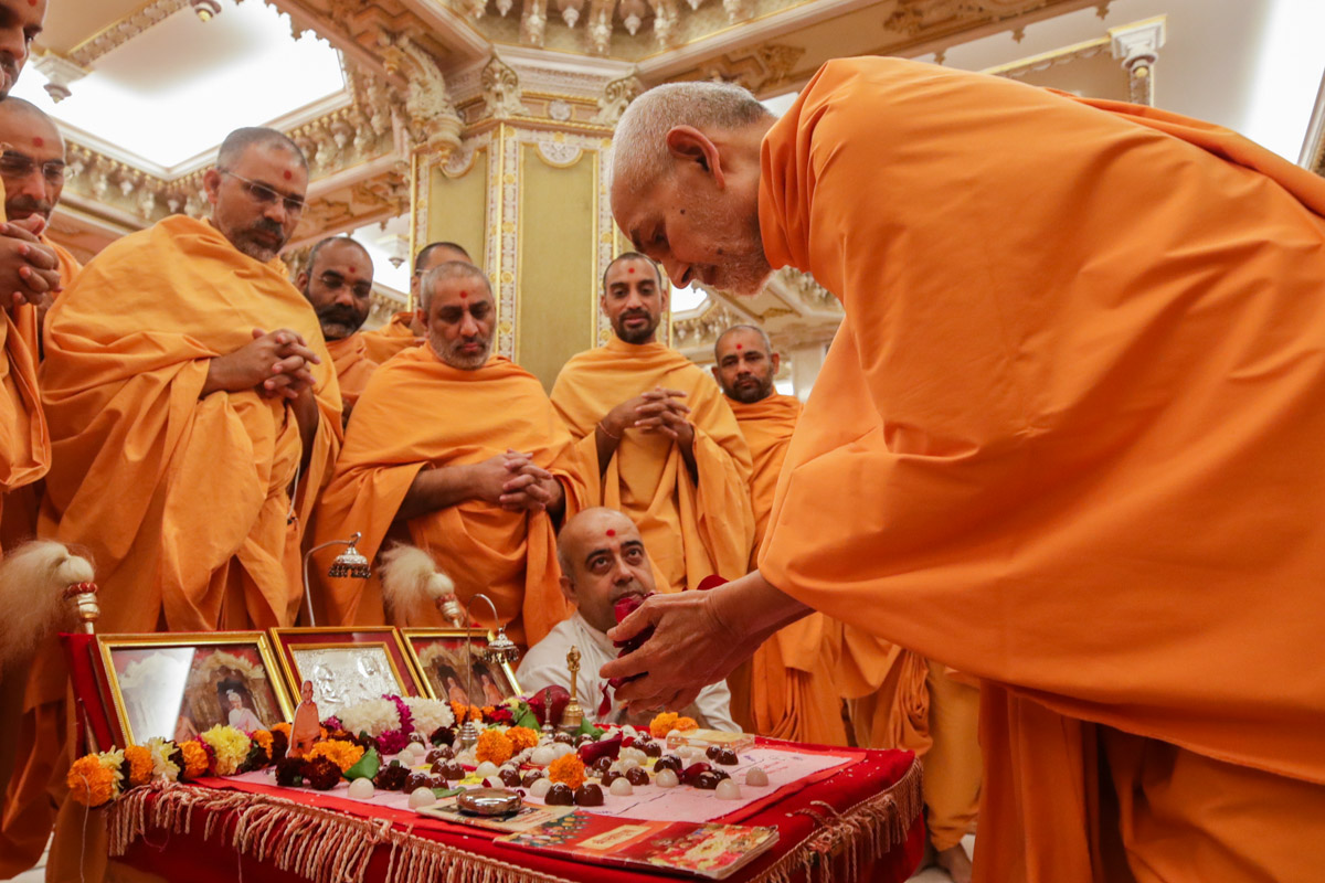 Swamishri offers mantra-pushpanjali in the morning mahapuja