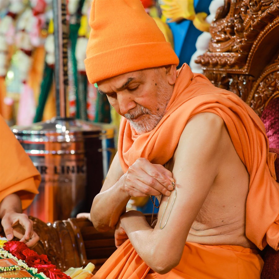 Swamishri applies tilak on his upper arm