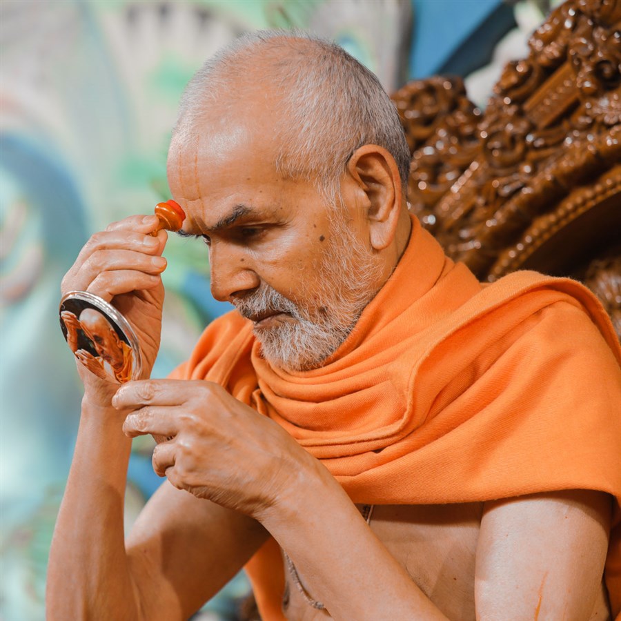 Swamishri applies chandlo on his forehead 