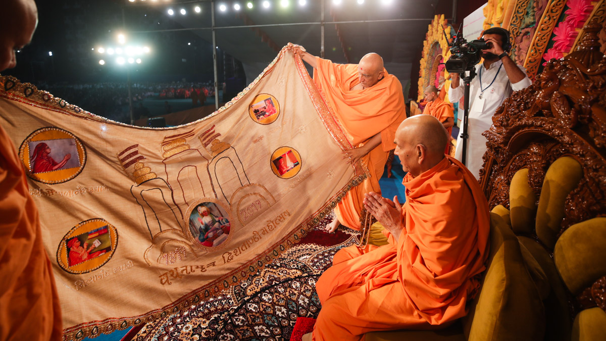 Swamishri observes a shawl made by devotees