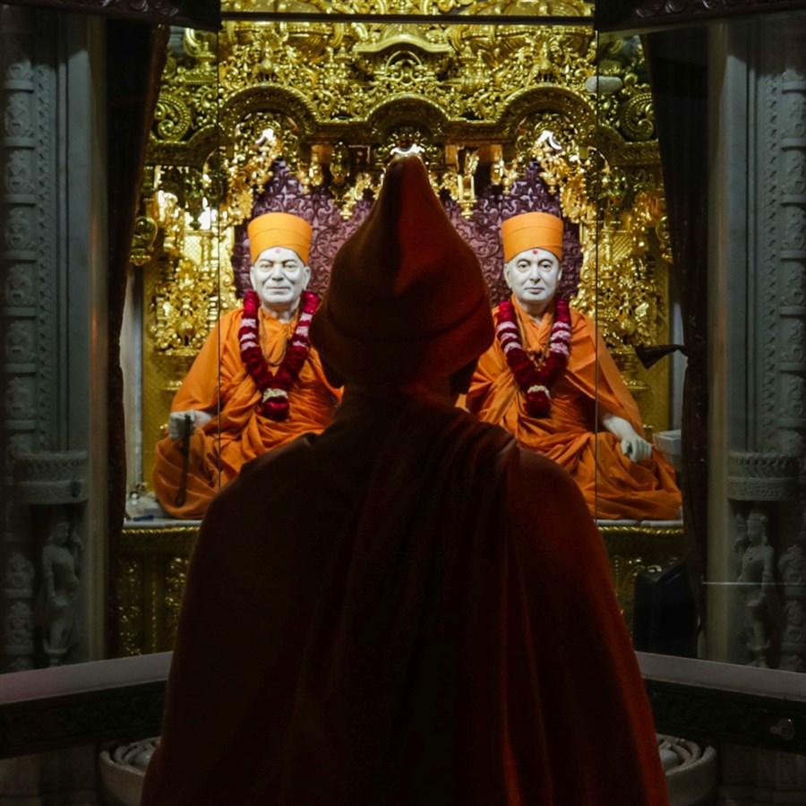 Swamishri engrossed in darshan of  Brahmaswarup Yogiji Maharaj and Brahmaswarup Pramukh Swami Maharaj
