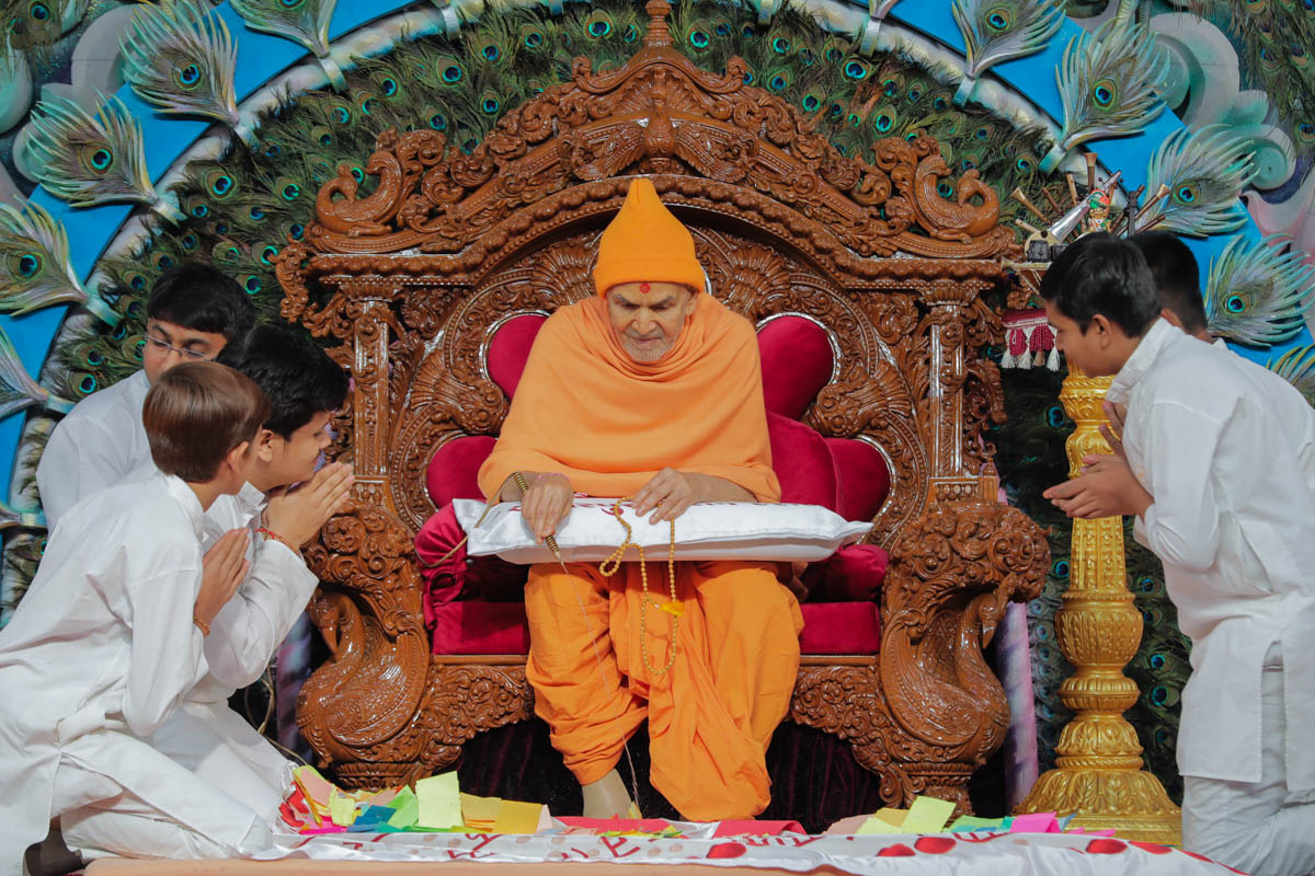 Swamishri sprays sanctified colored water