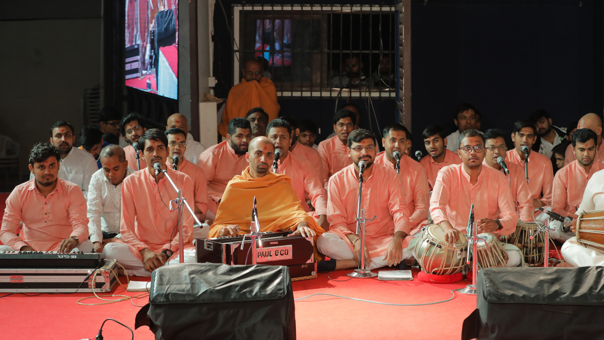 Youths sing kirtans in Swamishri's puja