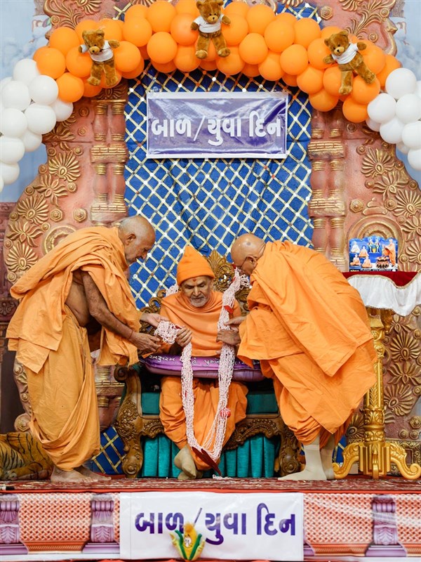 Pujya Tyagvallabh Swami and Sadhujivan Swami honor Swamishri with a garland