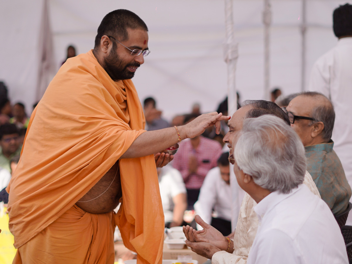 A sadhu applies chandlo to devotees
