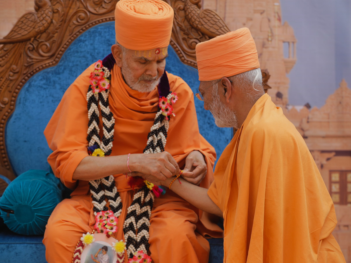 Swamishri ties a nadachhadi to Akshaymuni Swami
